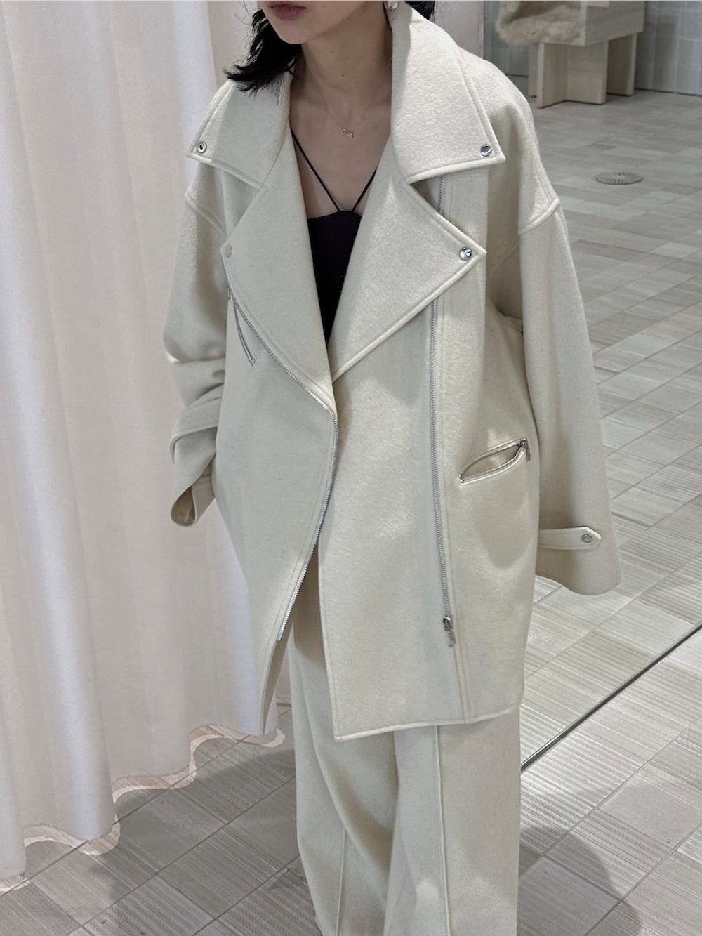 ホワイト系のピーコート、ホワイト系のスラックスを着用したレディースの秋コーディネートの4枚目の写真