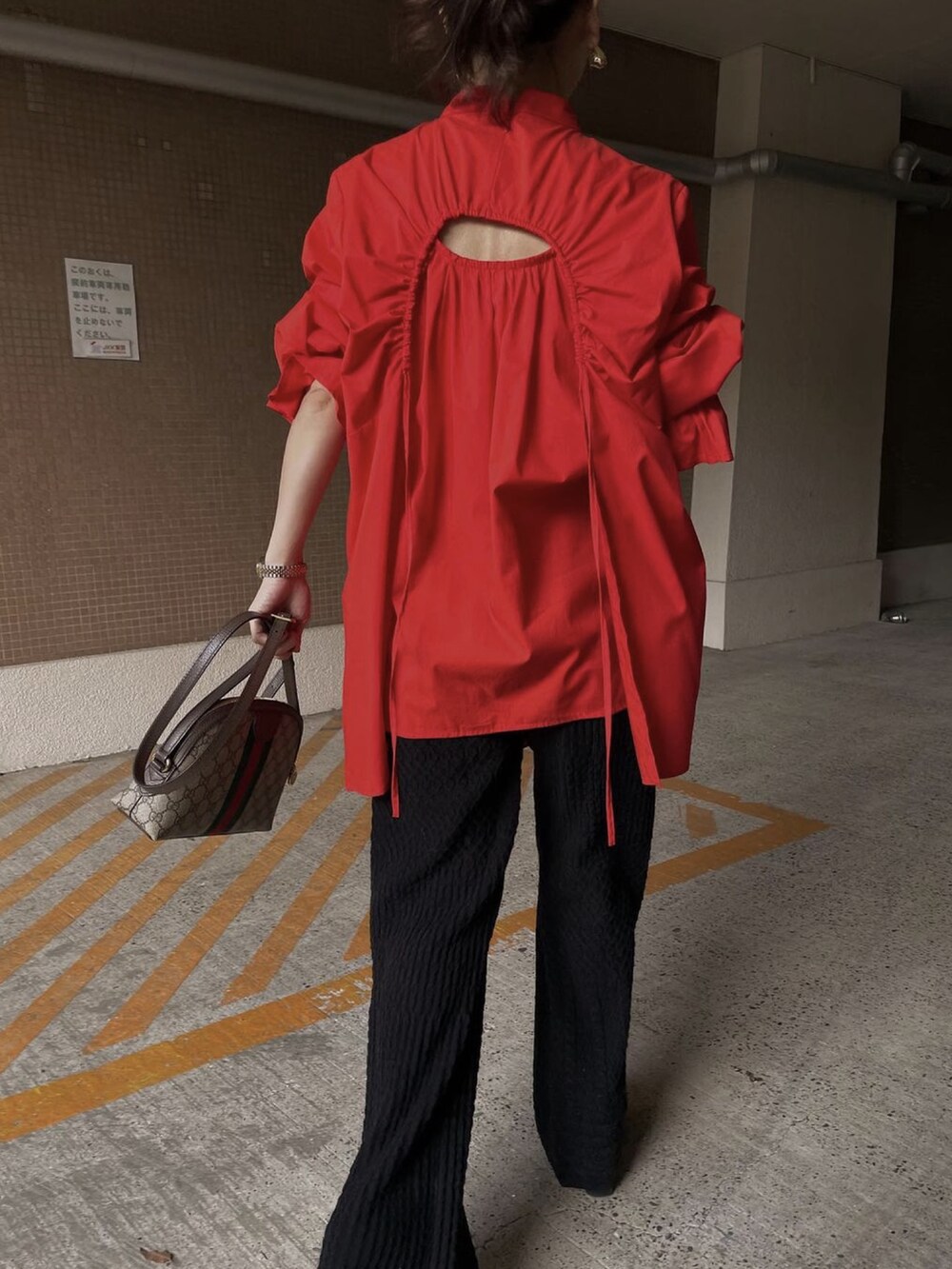 レッド系のシャツ/ブラウス、ブラック系のその他パンツ、ブラウン系のバッグを着用したレディースの冬コーディネートの5枚目の写真