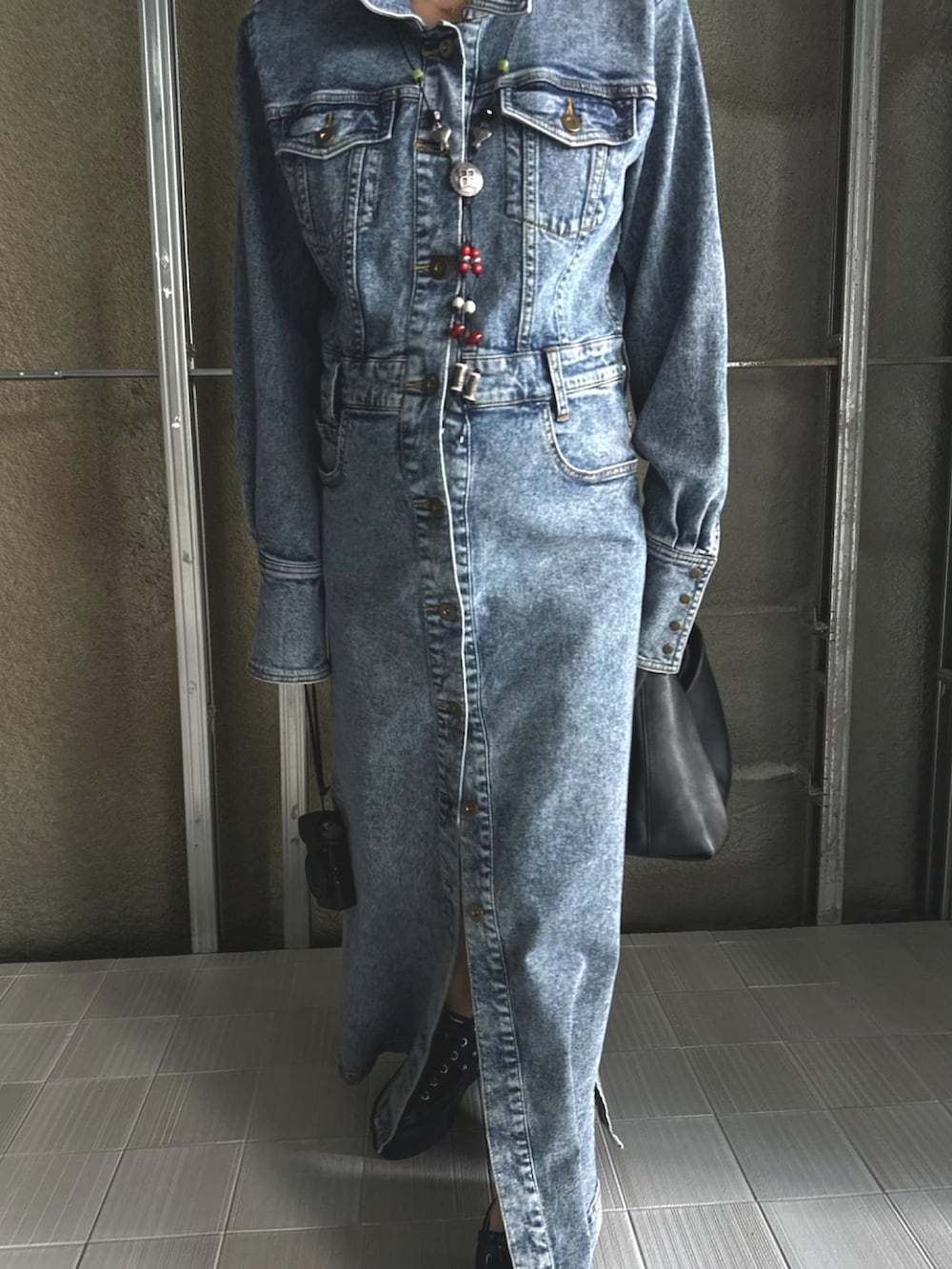 ブラック系のスニーカー、ブラック系のワンピース、シルバー系のネックレスを着用したレディースの秋コーディネートの4枚目の写真