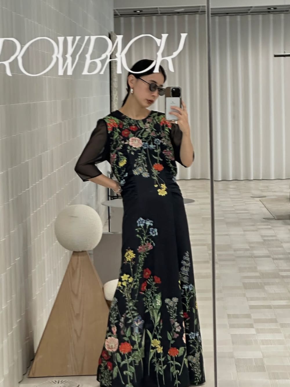 ブラック系のワンピース、ブラック系のトレンチコートを着用したレディースの秋コーディネートの2枚目の写真