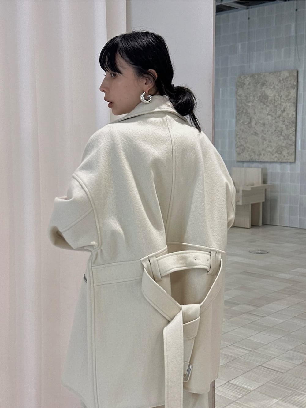 ホワイト系のピーコート、ホワイト系のスラックスを着用したレディースの秋コーディネートの3枚目の写真