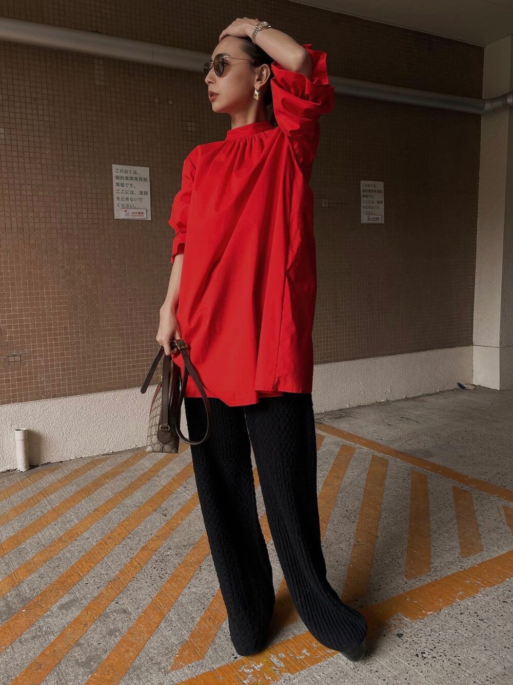 レッド系のシャツ/ブラウス、ブラック系のその他パンツ、ブラウン系のバッグを着用したレディースの冬コーディネートの4枚目の写真