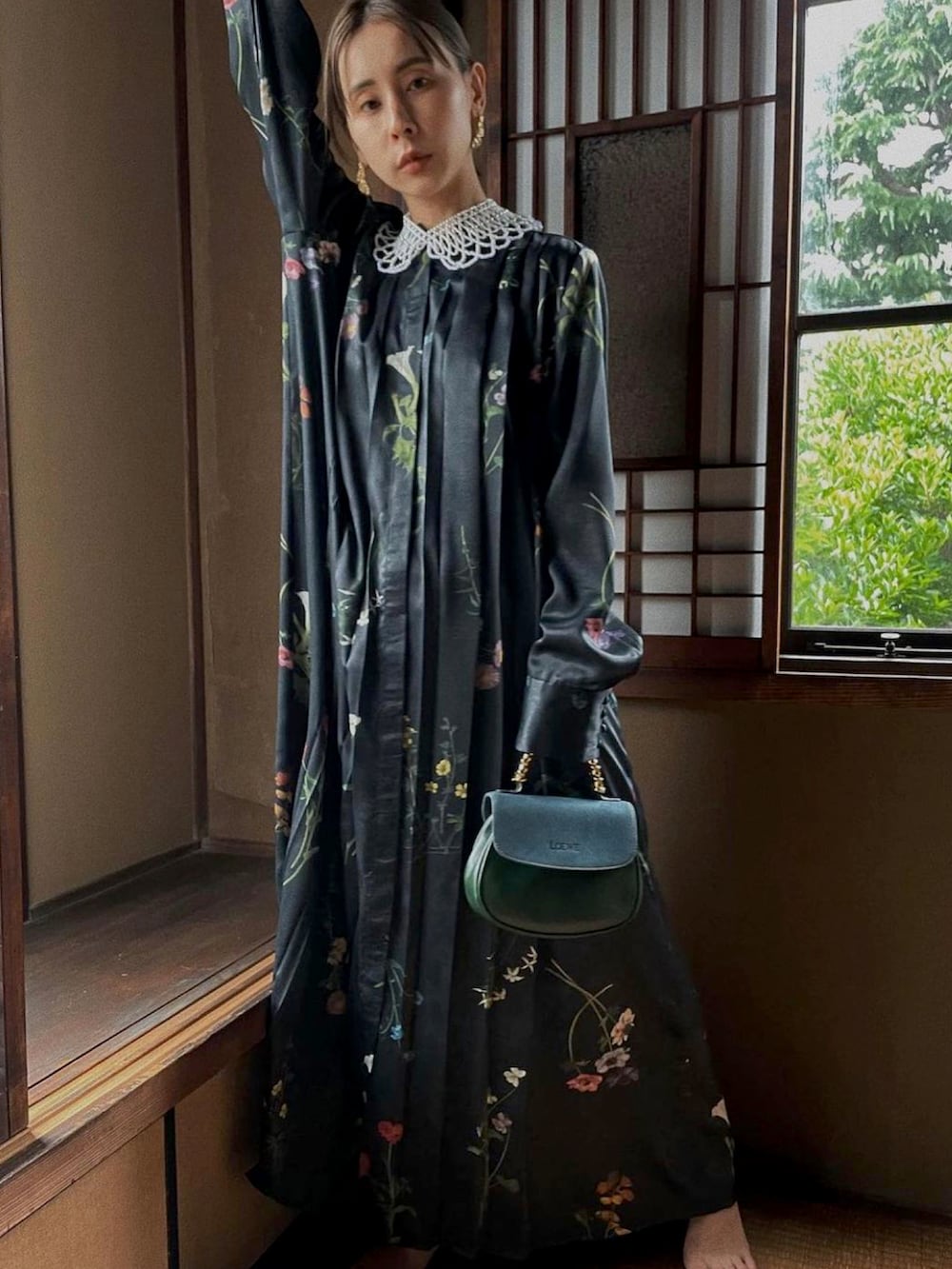 ブラック系のワンピース、ゴールド系のピアス（両耳用）、ホワイト系のチョーカーを着用したレディースの秋コーディネートの4枚目の写真