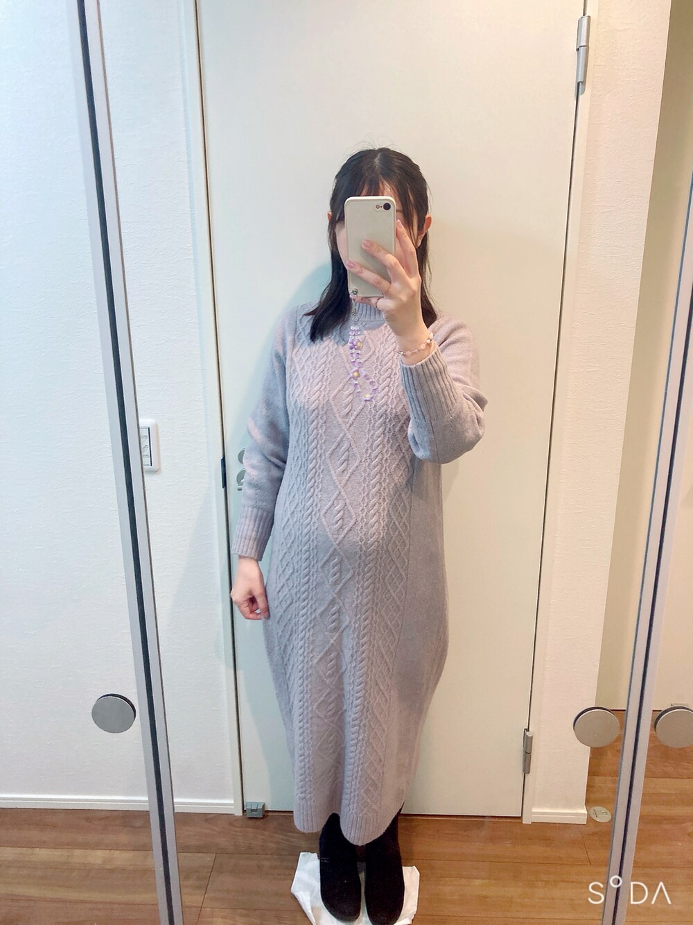 パープル系のワンピース、ホワイト系のジャケット/アウター、ブラック系のブーツを着用したレディースの冬コーディネートの2枚目の写真