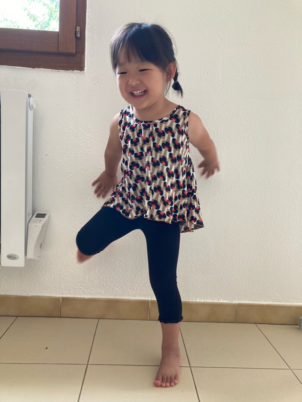 ブラック系のタンクトップ、ホワイト系のレギンス/スパッツを着用したキッズの夏コーディネートの2枚目の写真