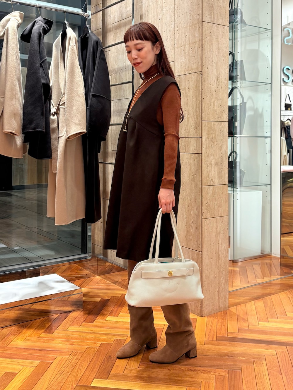 ブラウン系のワンピース、ブラウン系のニット/セーター、ブラウン系のブーツを着用したレディースの秋コーディネートの2枚目の写真