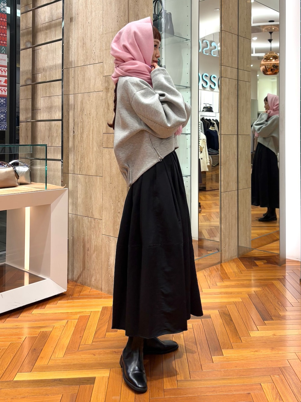 グレー系のTシャツ/カットソー、ブラック系のスカート、その他のハンドバッグを着用したレディースの秋コーディネートの5枚目の写真