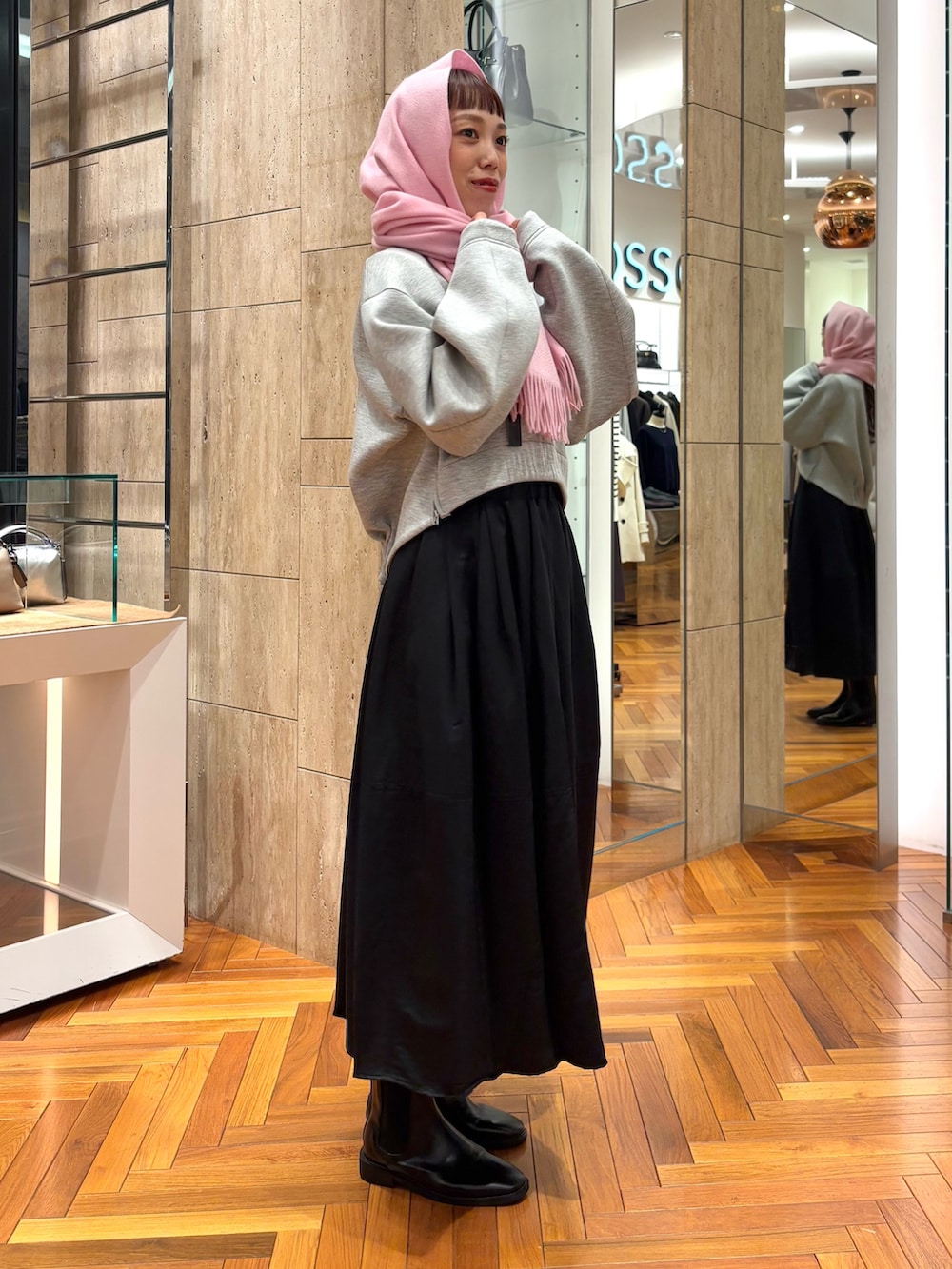 グレー系のTシャツ/カットソー、ブラック系のスカート、その他のハンドバッグを着用したレディースの秋コーディネートの4枚目の写真