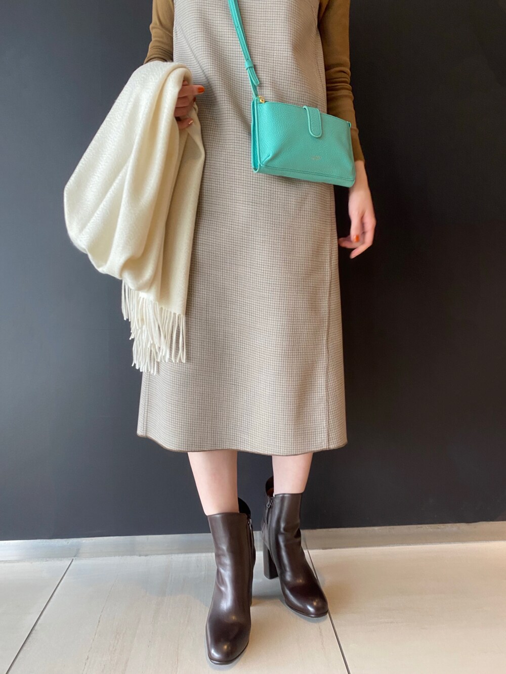 ブラウン系のワンピース、グリーン系のバッグ、ブラウン系のブーツを着用したレディースの秋コーディネートの3枚目の写真