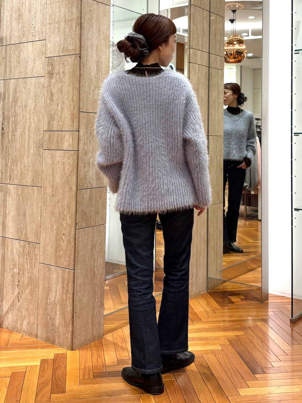 ブルー系のニット/セーター、ブラック系のブーツ、グレー系のヘアゴムを着用したレディースの冬コーディネートの3枚目の写真