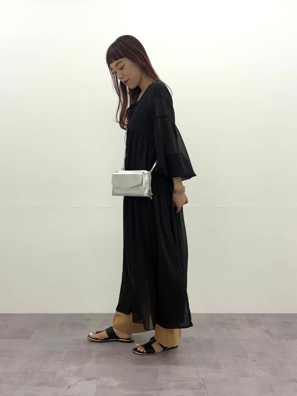 ブラック系のワンピース、シルバー系のショルダーバッグ、イエロー系のその他パンツを着用したレディースの春コーディネートの2枚目の写真