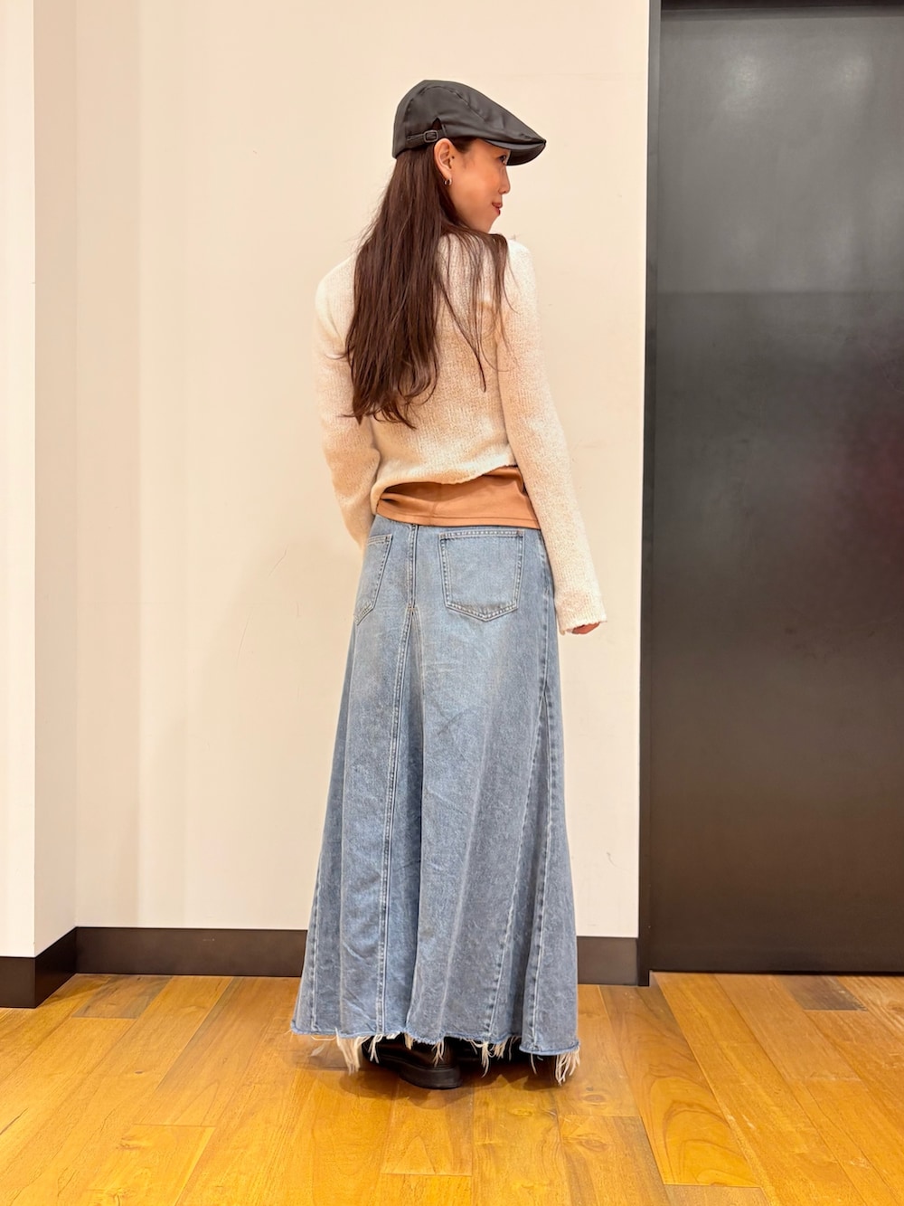 ホワイト系のカーディガン/ボレロ、オレンジ系のタンクトップ、ブルー系のスカートを着用したレディースの秋コーディネートの3枚目の写真