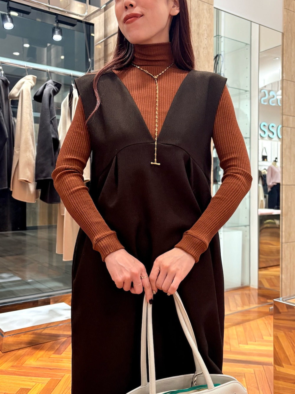 ブラウン系のワンピース、ブラウン系のニット/セーター、ブラウン系のブーツを着用したレディースの秋コーディネートの5枚目の写真