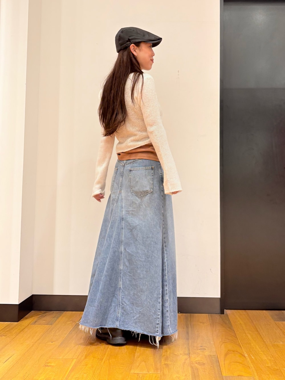 ホワイト系のカーディガン/ボレロ、オレンジ系のタンクトップ、ブルー系のスカートを着用したレディースの秋コーディネートの2枚目の写真