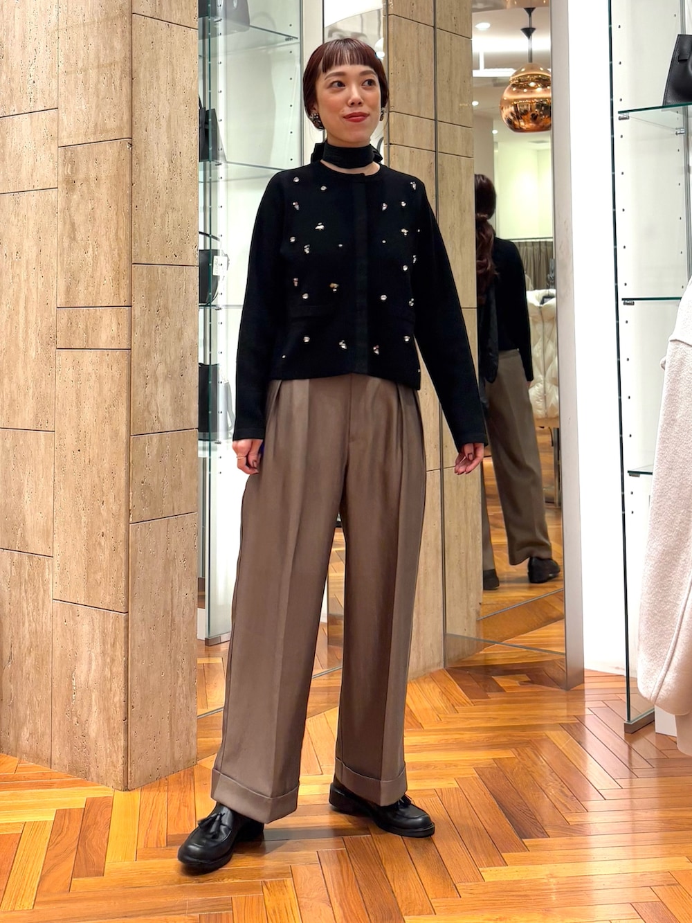 ブラック系のカーディガン/ボレロ、ブラウン系のその他パンツ、ブラック系のローファーを着用したレディースの秋コーディネートの4枚目の写真