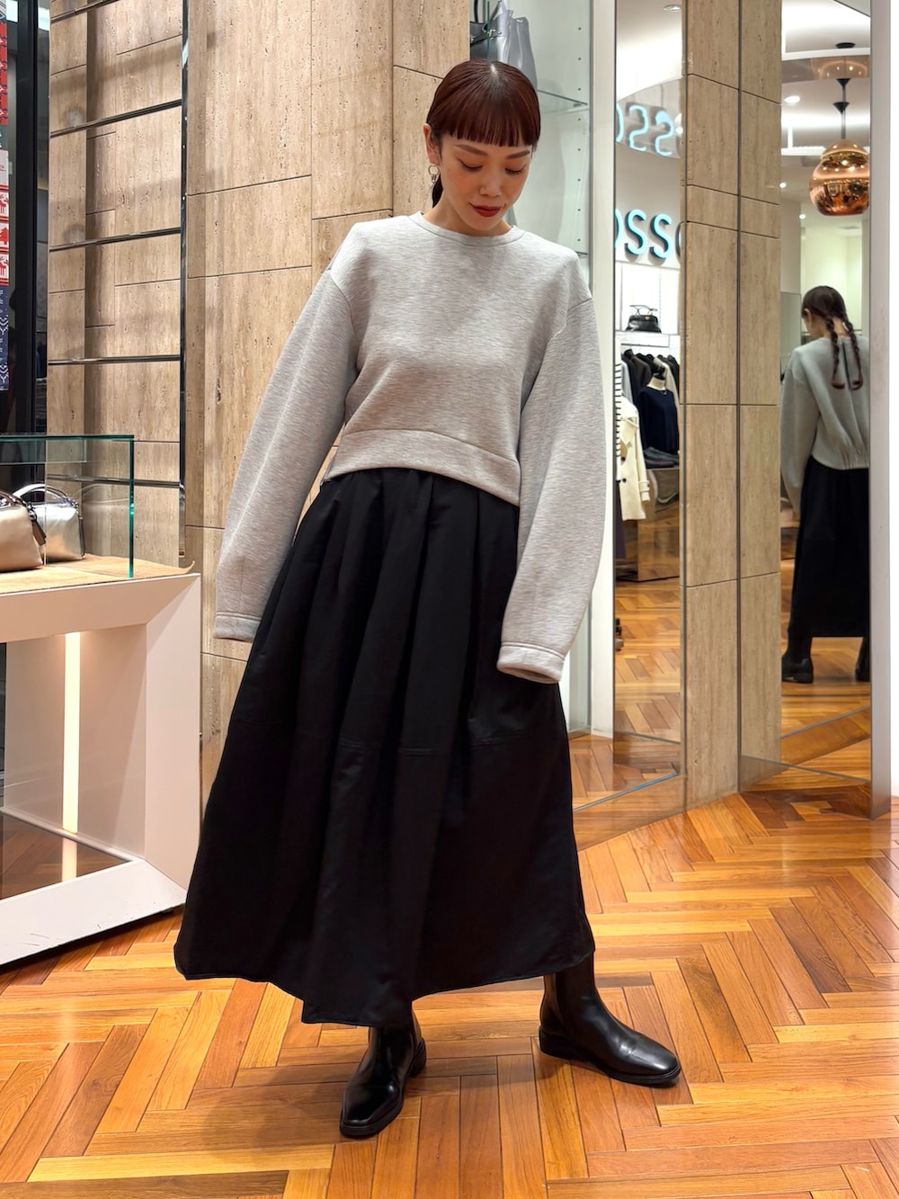 グレー系のTシャツ/カットソー、ブラック系のスカート、その他のハンドバッグを着用したレディースの秋コーディネートの6枚目の写真