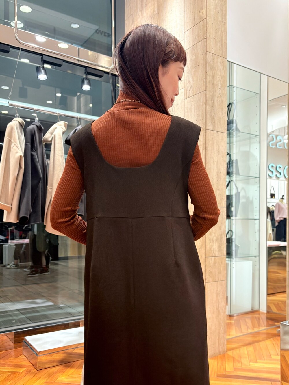 ブラウン系のワンピース、ブラウン系のニット/セーター、ブラウン系のブーツを着用したレディースの秋コーディネートの6枚目の写真