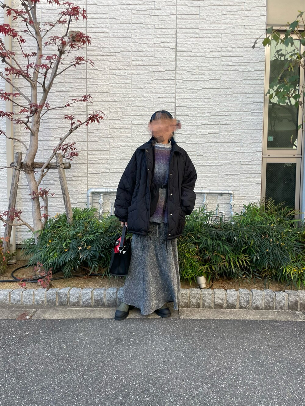 ブラック系のスカート、ブラック系のブルゾンを着用したレディースの冬コーディネートの3枚目の写真