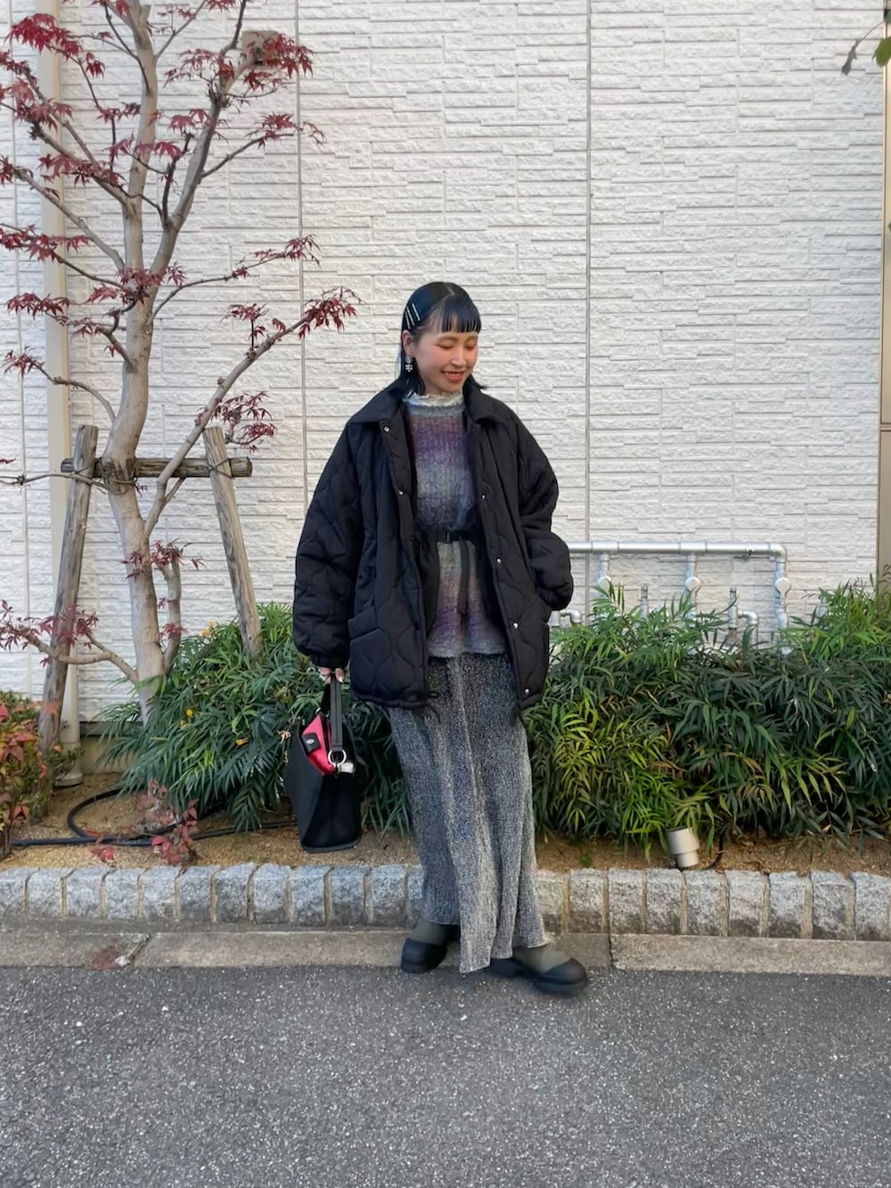 ブラック系のスカート、ブラック系のブルゾンを着用したレディースの冬コーディネートの4枚目の写真