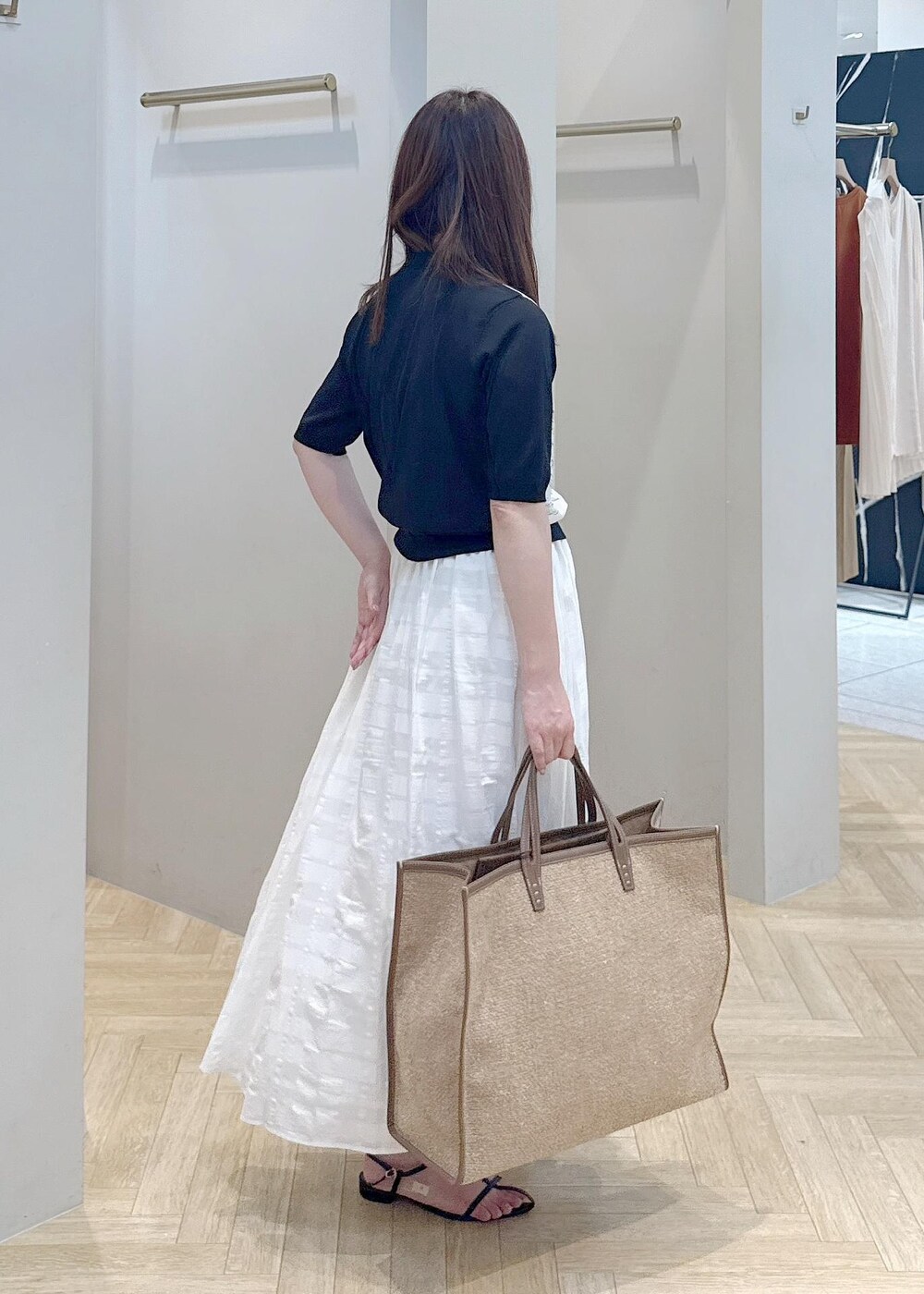 ホワイト系のスカート、ブラック系のシャツ/ブラウスを着用したレディースの夏コーディネートの2枚目の写真