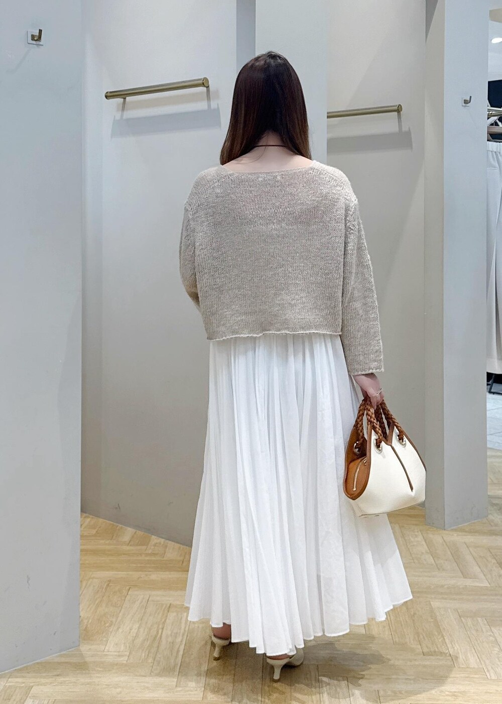 ホワイト系のスカート、ベージュ系のサンダル、ベージュ系のニット/セーターを着用したレディースの春コーディネートの3枚目の写真
