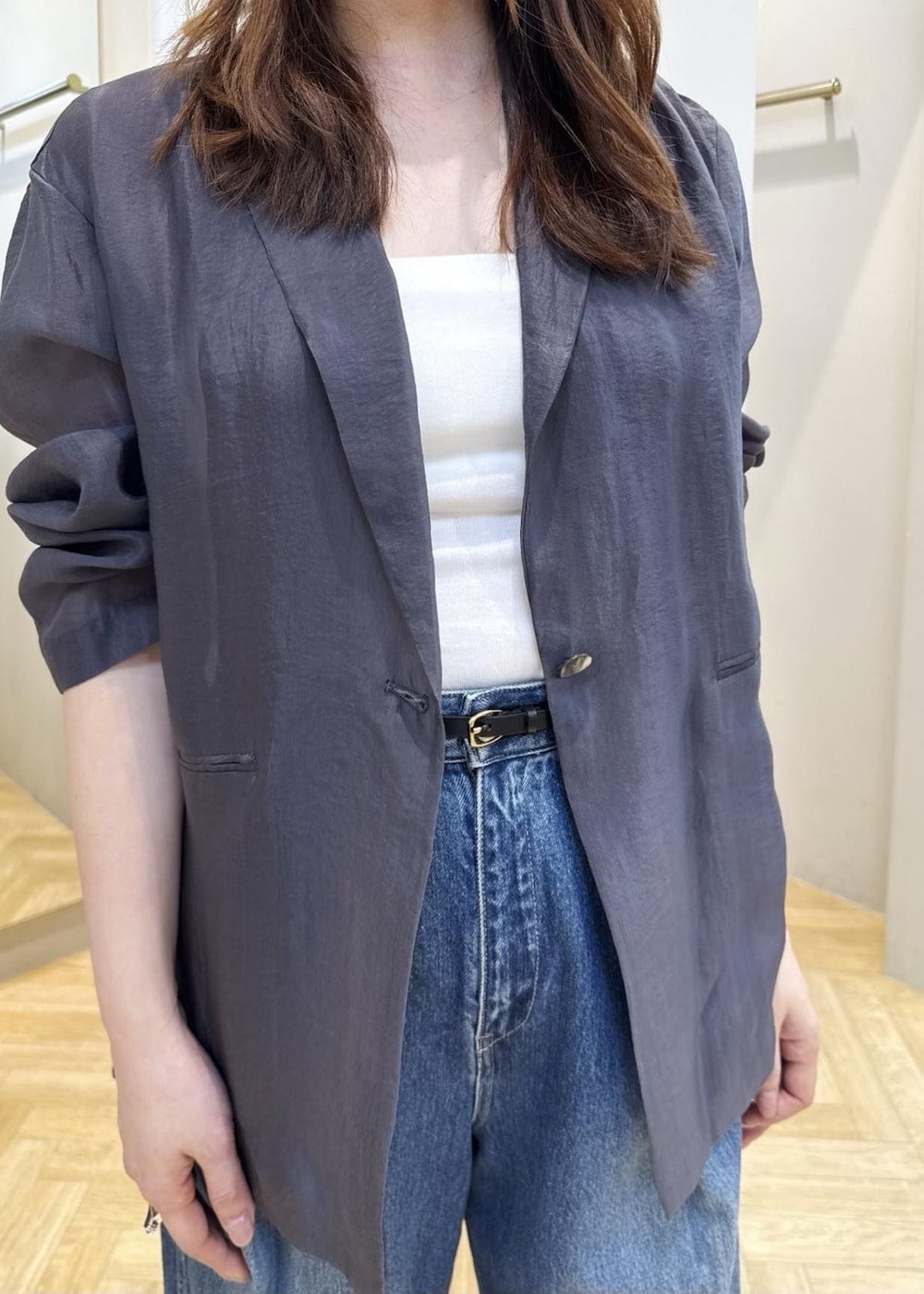 ブルー系のデニムパンツ、シルバー系のパンプス、グレー系のテーラードジャケットを着用したレディースの春コーディネートの4枚目の写真