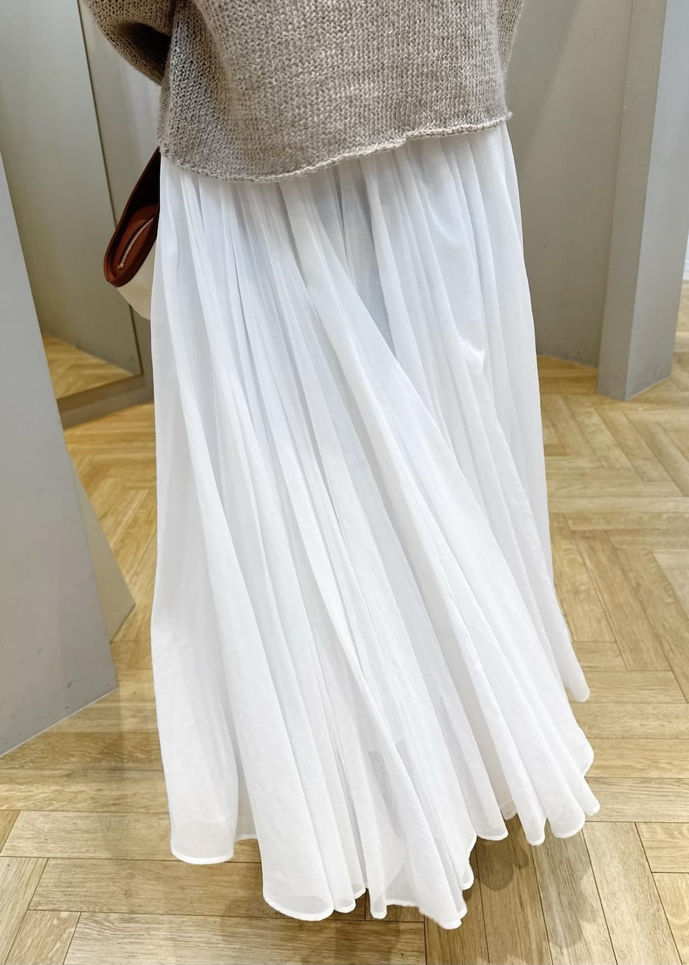 ホワイト系のスカート、ベージュ系のサンダル、ベージュ系のニット/セーターを着用したレディースの春コーディネートの5枚目の写真