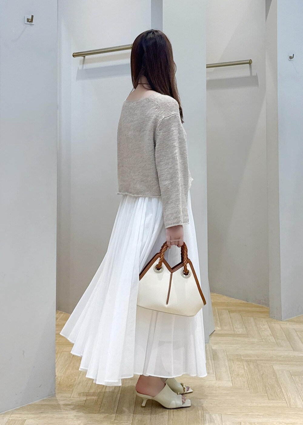 ホワイト系のスカート、ベージュ系のサンダル、ベージュ系のニット/セーターを着用したレディースの春コーディネートの2枚目の写真