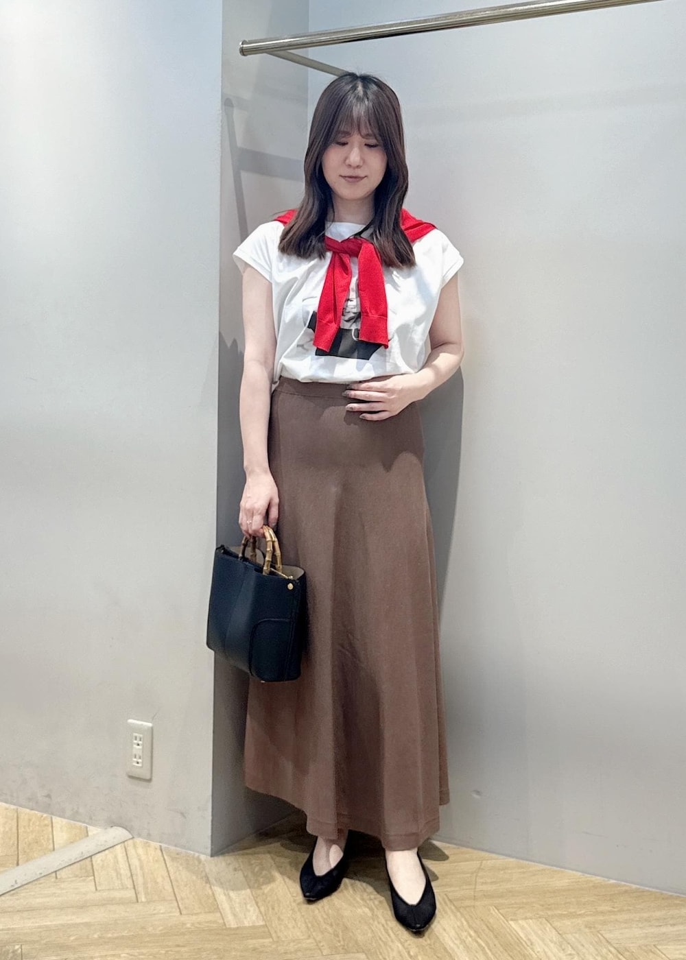 ブラック系のパンプス、ホワイト系のTシャツ/カットソー、ブラック系のハンドバッグを着用したレディースの夏コーディネートの6枚目の写真