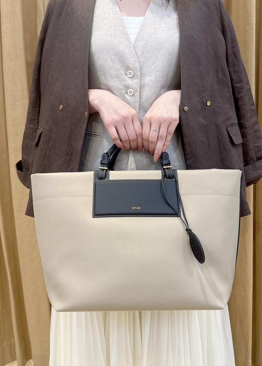 シルバー系のパンプス、ベージュ系のトートバッグ、ブラウン系のノーカラージャケットを着用したレディースの春コーディネートの5枚目の写真