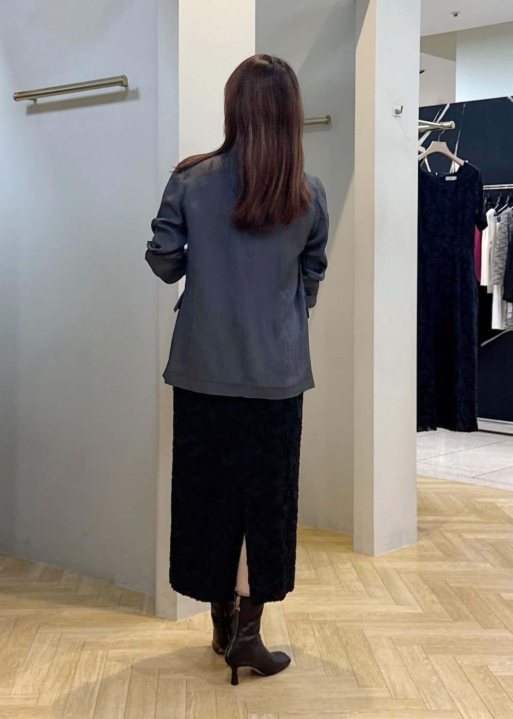 グレー系のテーラードジャケット、ブラック系のスカートを着用したレディースの秋コーディネートの5枚目の写真