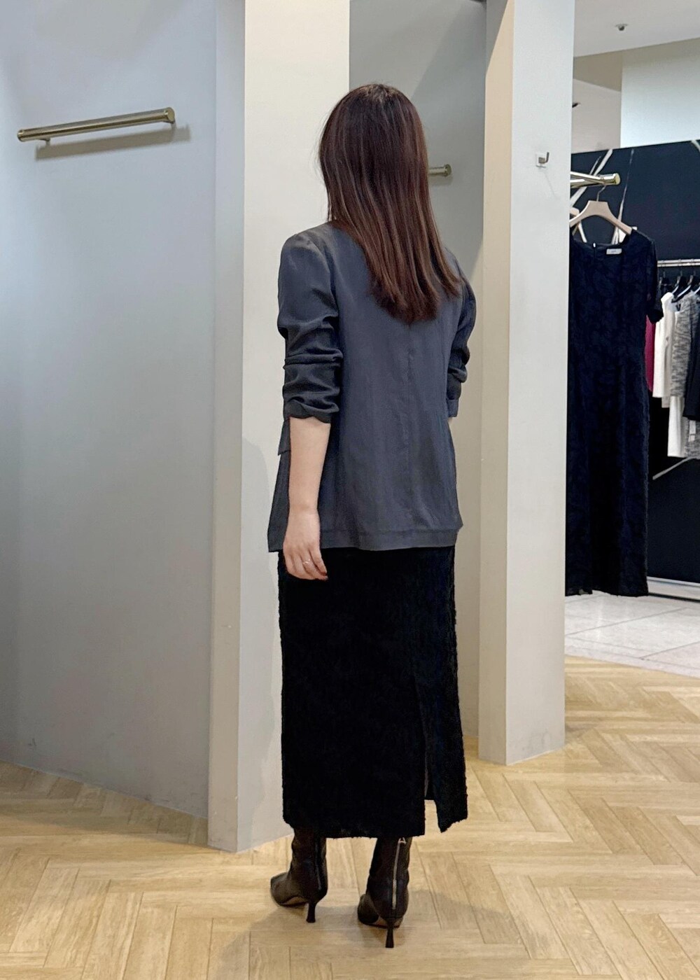 グレー系のテーラードジャケット、ブラック系のスカートを着用したレディースの秋コーディネートの4枚目の写真