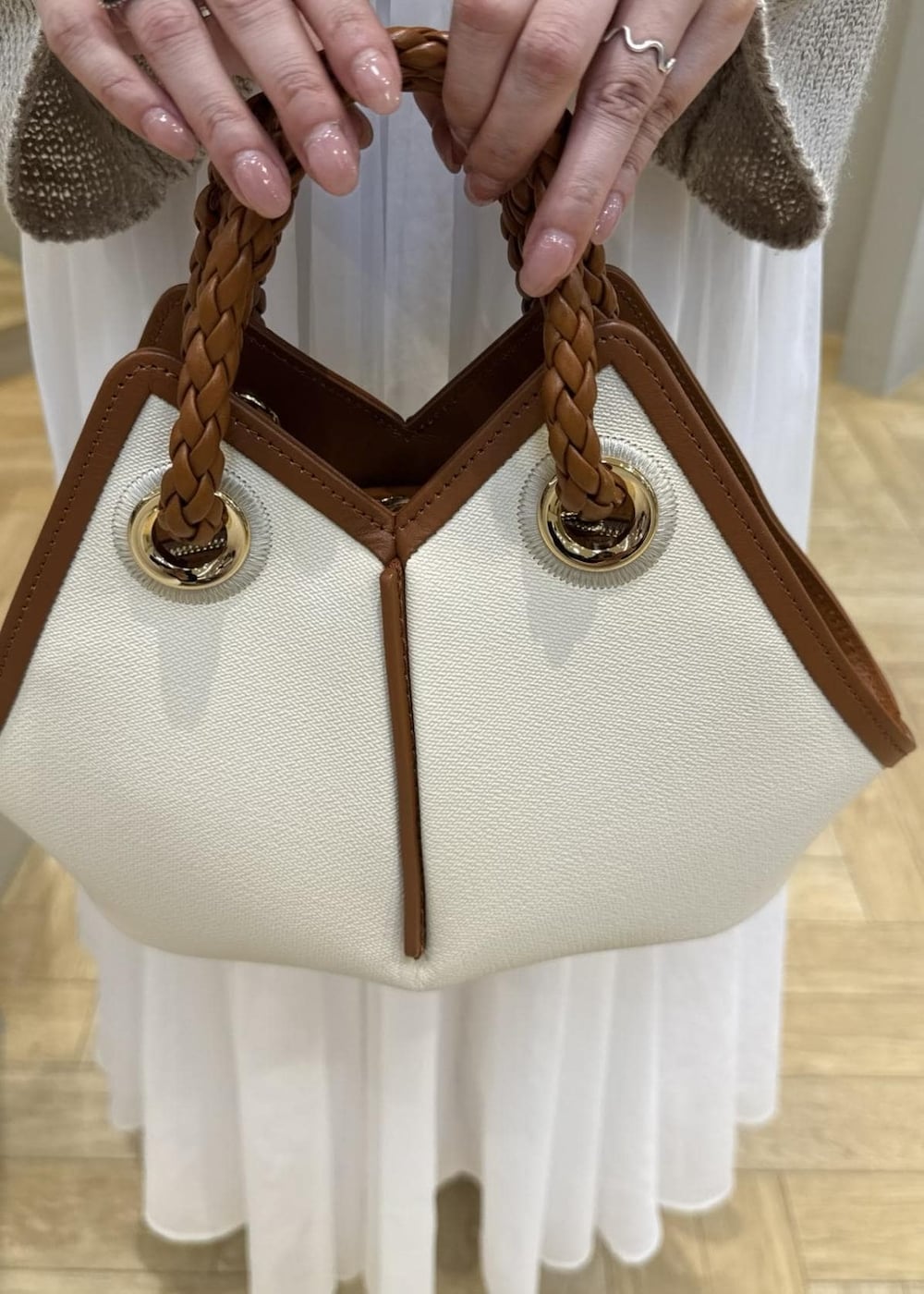 ホワイト系のスカート、ベージュ系のサンダル、ベージュ系のニット/セーターを着用したレディースの春コーディネートの6枚目の写真