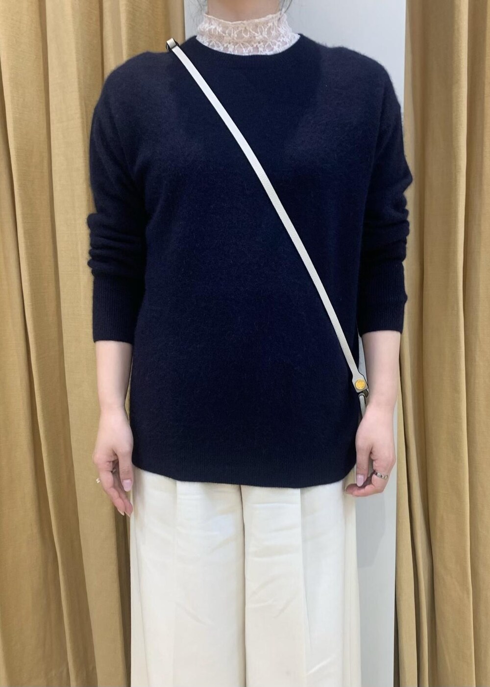 ブルー系のニット/セーター、ホワイト系のその他パンツ、ホワイト系のショルダーバッグを着用したレディースの冬コーディネートの4枚目の写真