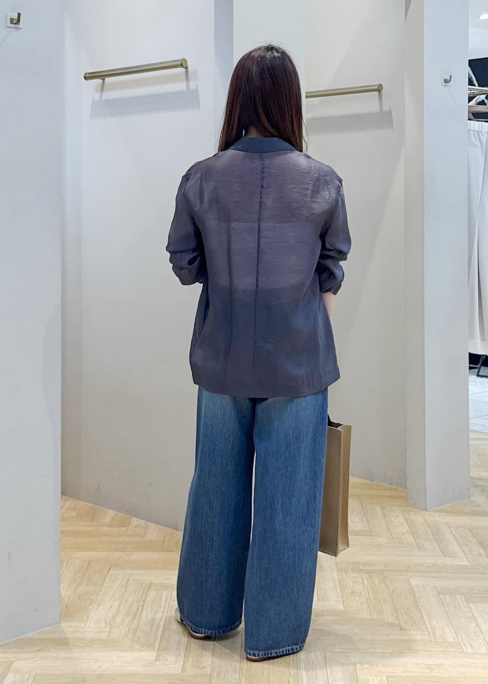 ブルー系のデニムパンツ、シルバー系のパンプス、グレー系のテーラードジャケットを着用したレディースの春コーディネートの2枚目の写真