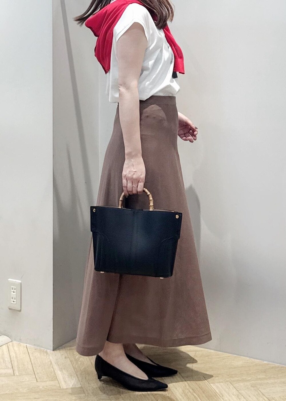 ブラック系のパンプス、ホワイト系のTシャツ/カットソー、ブラック系のハンドバッグを着用したレディースの夏コーディネートの4枚目の写真