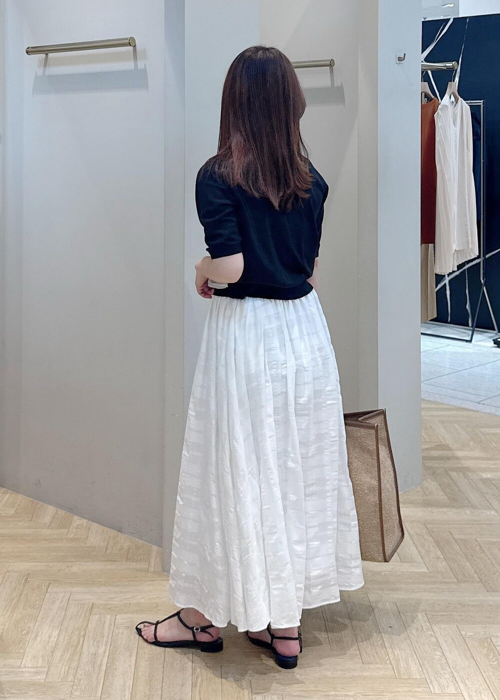 ホワイト系のスカート、ブラック系のシャツ/ブラウスを着用したレディースの夏コーディネートの3枚目の写真