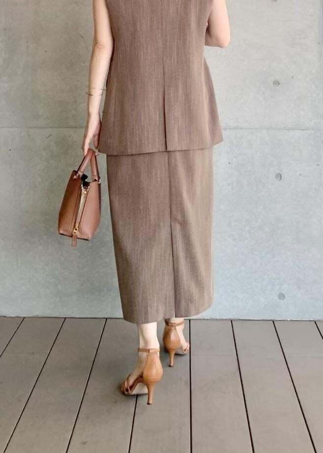 ブラウン系のハンドバッグ、ブラウン系のベスト、ホワイト系のTシャツ/カットソーを着用したレディースの夏コーディネートの4枚目の写真