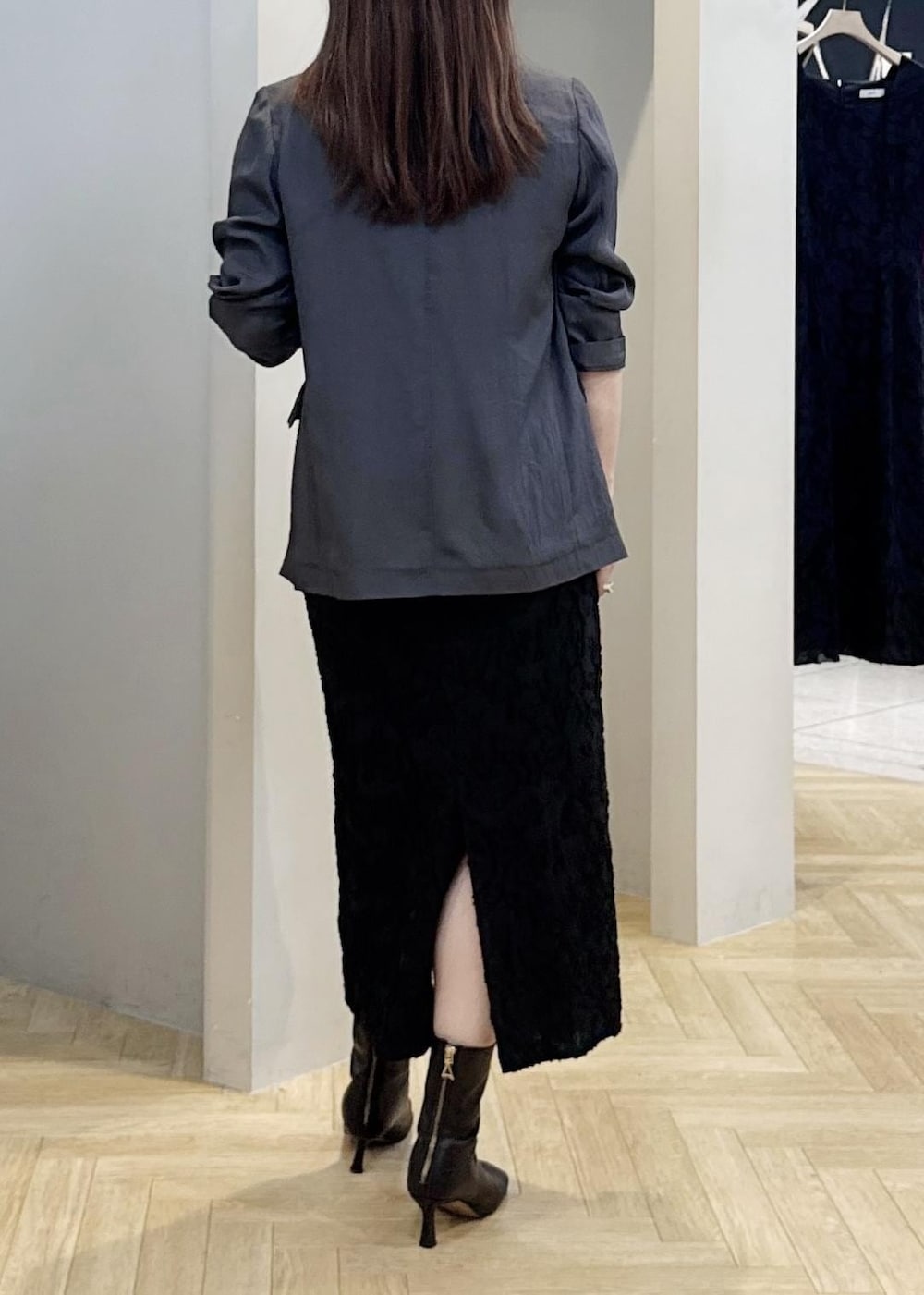 グレー系のテーラードジャケット、ブラック系のスカートを着用したレディースの秋コーディネートの6枚目の写真