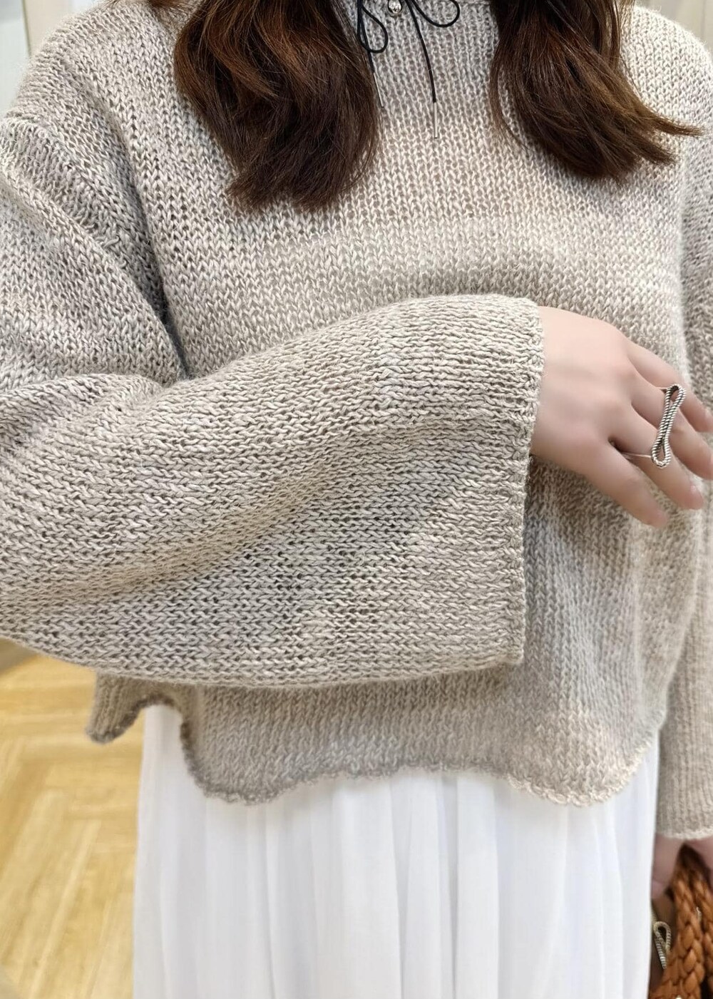 ホワイト系のスカート、ベージュ系のサンダル、ベージュ系のニット/セーターを着用したレディースの春コーディネートの4枚目の写真