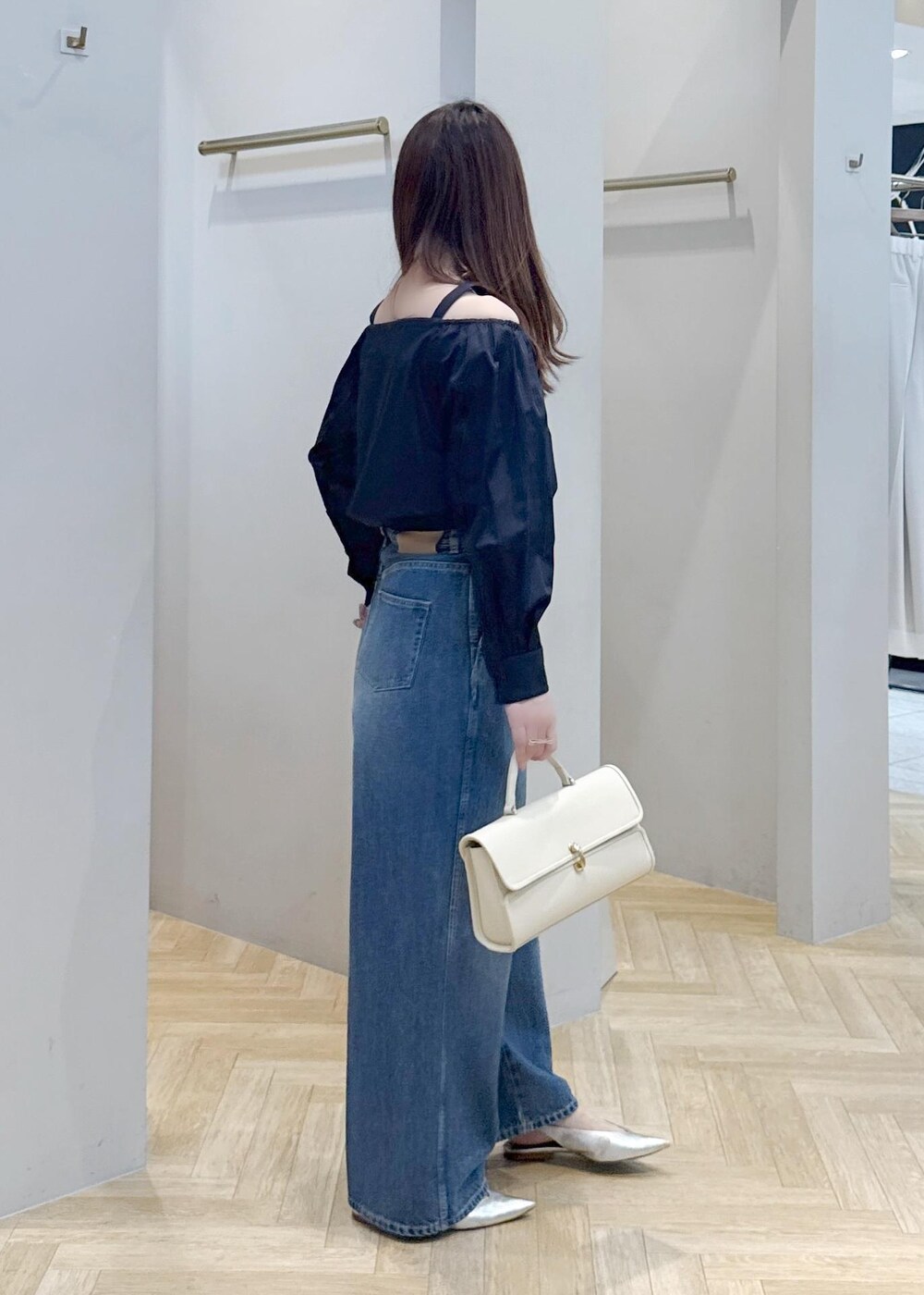 ブルー系のデニムパンツ、ベージュ系のショルダーバッグ、シルバー系のパンプスを着用したレディースの春コーディネートの2枚目の写真