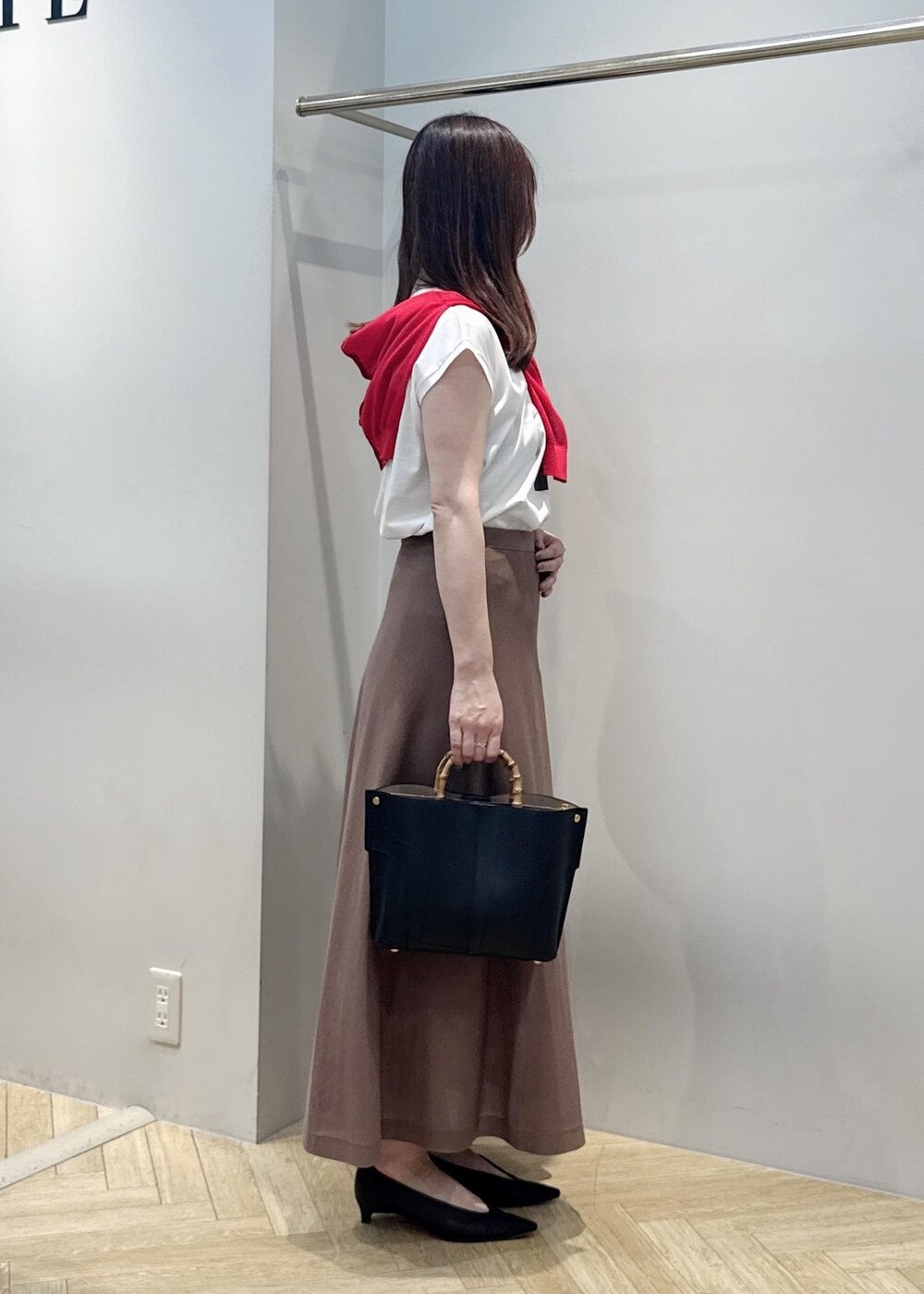 ブラック系のパンプス、ホワイト系のTシャツ/カットソー、ブラック系のハンドバッグを着用したレディースの夏コーディネートの2枚目の写真