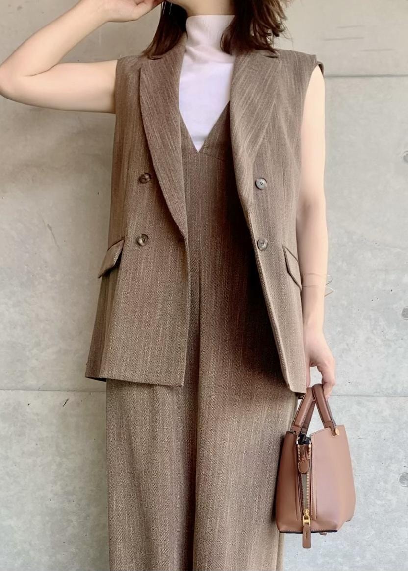 ブラウン系のハンドバッグ、ブラウン系のベスト、ホワイト系のTシャツ/カットソーを着用したレディースの夏コーディネートの2枚目の写真