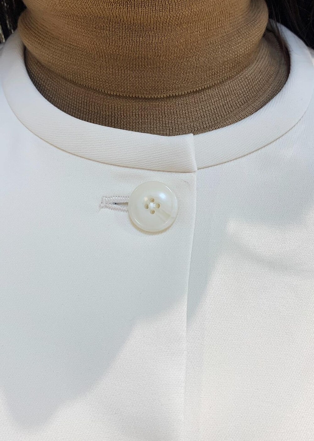 ブラック系のパンプス、ベージュ系のハンドバッグ、ホワイト系のスカートを着用したレディースの冬コーディネートの5枚目の写真