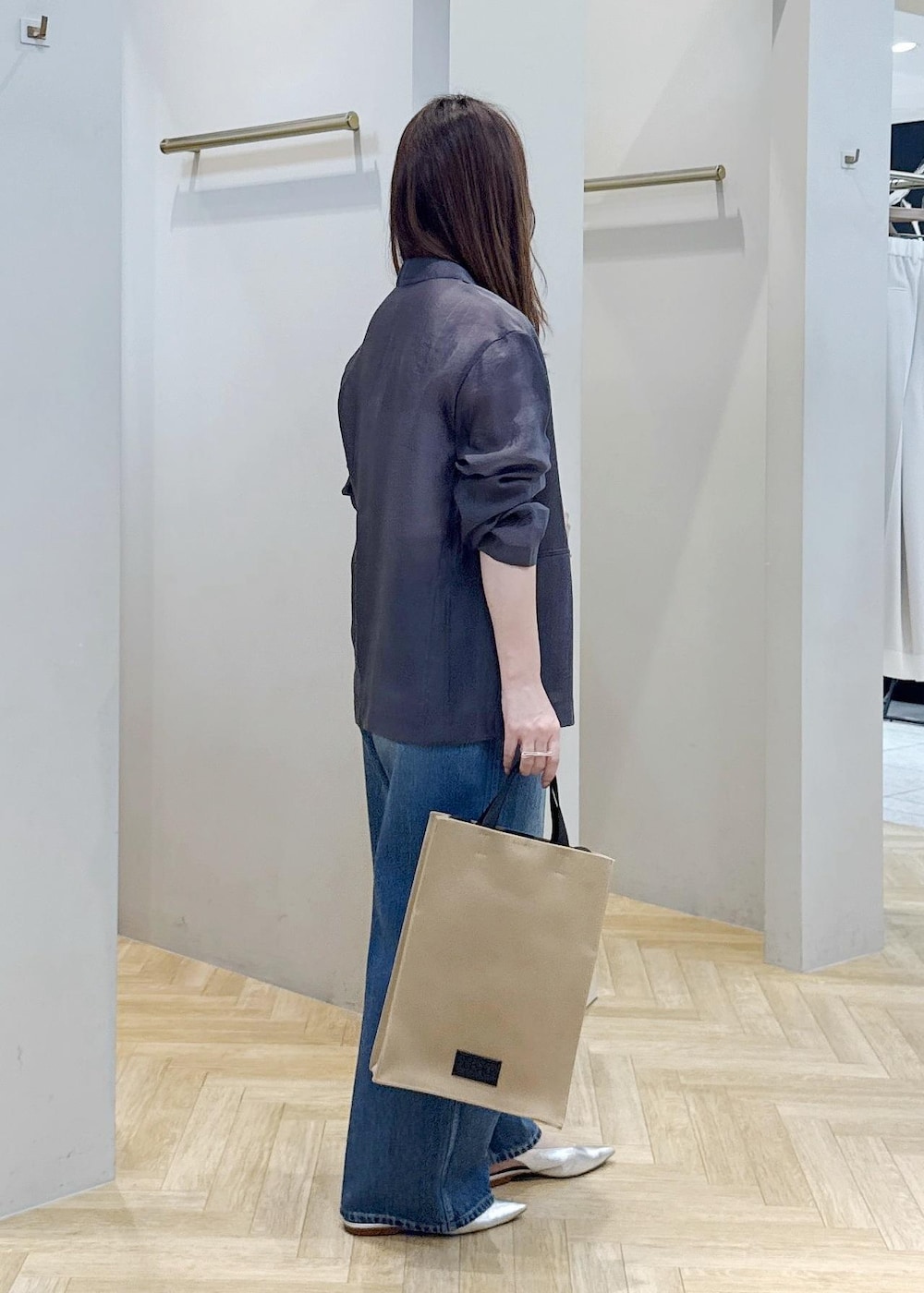 ブルー系のデニムパンツ、シルバー系のパンプス、グレー系のテーラードジャケットを着用したレディースの春コーディネートの3枚目の写真