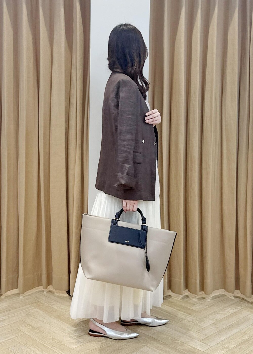 シルバー系のパンプス、ベージュ系のトートバッグ、ブラウン系のノーカラージャケットを着用したレディースの春コーディネートの2枚目の写真