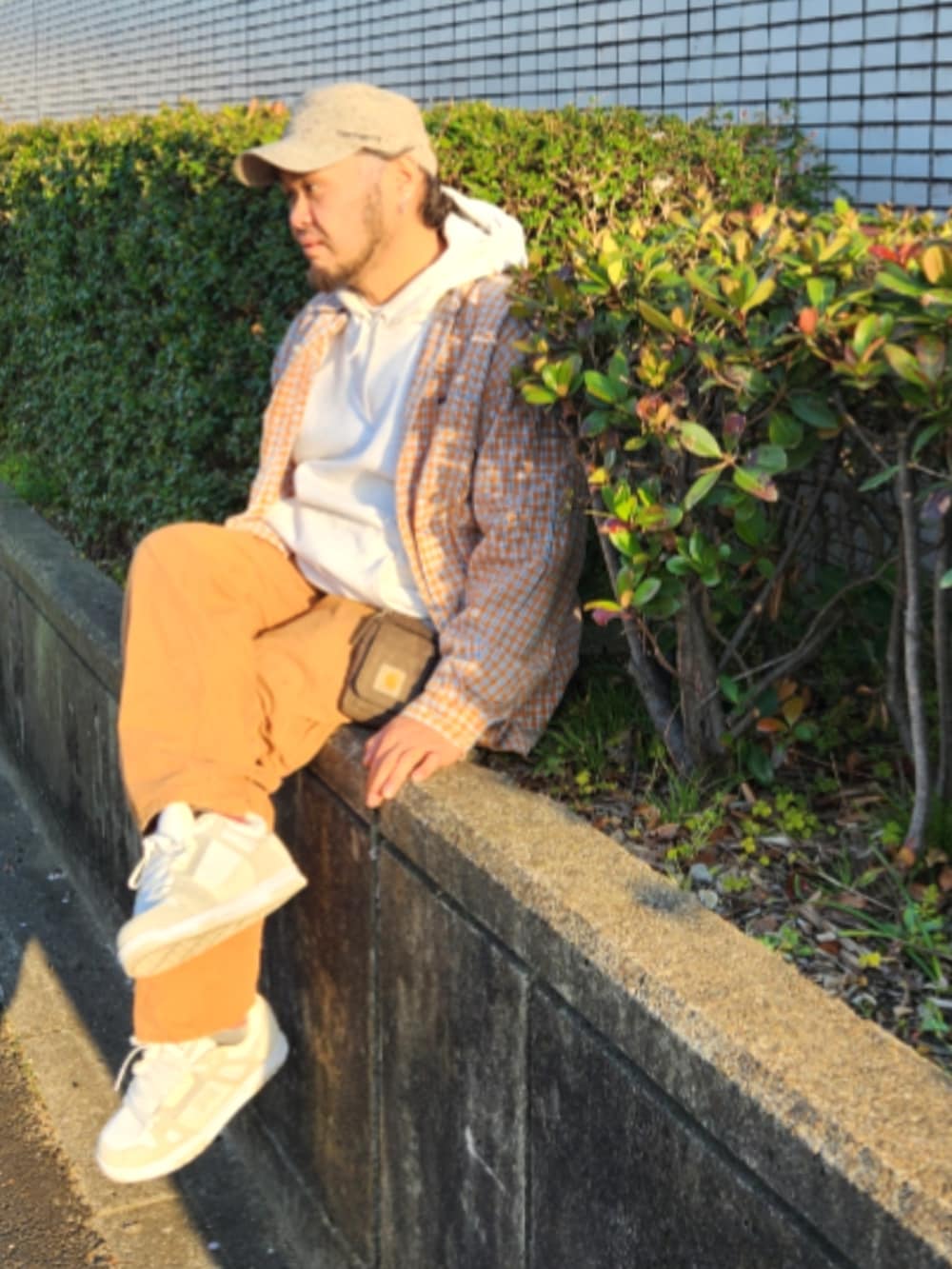 ホワイト系のスニーカー、ブラウン系のカーゴパンツ、グレー系のパーカーを着用したメンズの春コーディネートの3枚目の写真