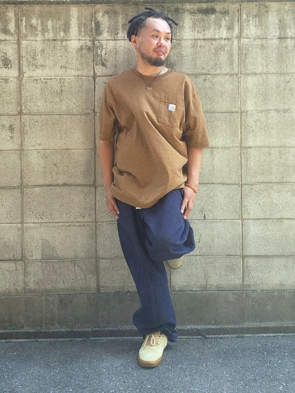 ブルー系のパンツ、ベージュ系のスニーカー、ブラウン系のTシャツ/カットソーを着用したメンズの春コーディネートの4枚目の写真
