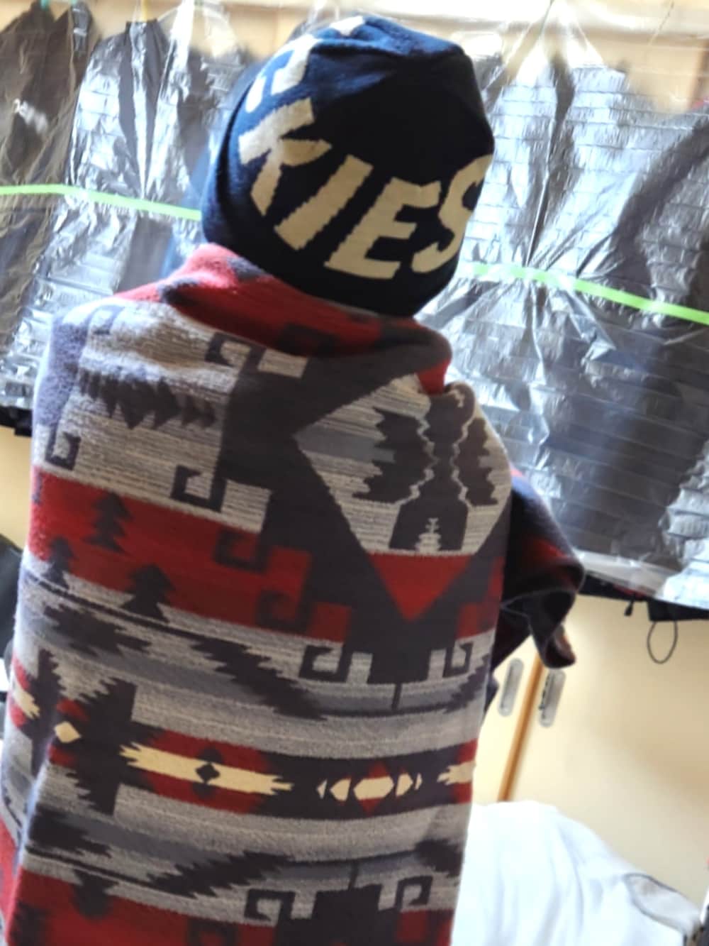 ブラウン系のミリタリージャケット、イエロー系のナイロンジャケット、ブラック系のパーカーを着用したメンズの春コーディネートの5枚目の写真