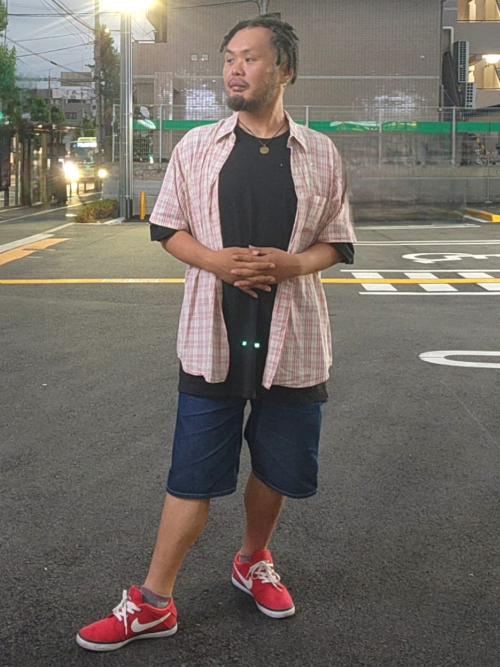 レッド系のスニーカー、ブルー系のデニムパンツ、ブラック系のTシャツ/カットソーを着用したメンズの春コーディネートの4枚目の写真
